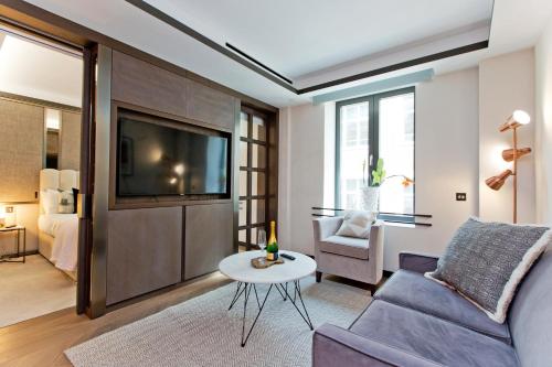 a living room with a couch and a tv at 37GS Residences in London