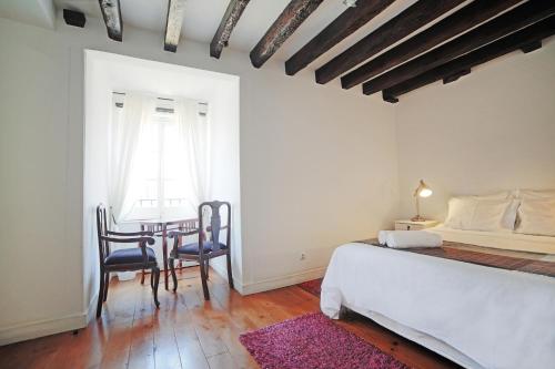 a bedroom with a bed and a table and chairs at Rossio Hostel in Lisbon