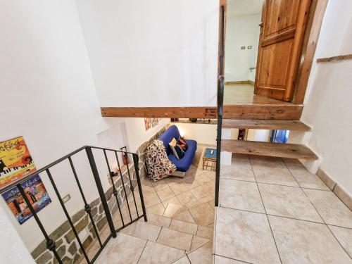 a staircase in a house with a blue chair at Il Borgo 4 in Capoliveri