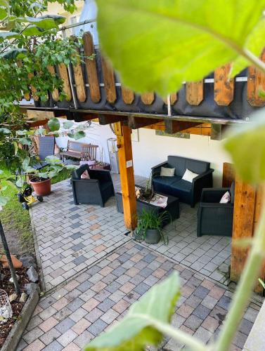 a patio with couches and chairs on a brick patio at Ferienhof Neukirchinger in Tiefenbach