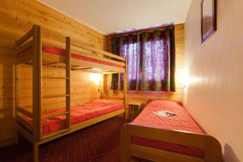 a bedroom with two bunk beds and a window at Vacancéole - Résidence Cabourg in Mont-de-Lans