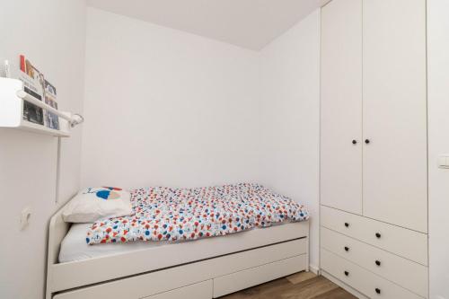 1 dormitorio blanco con 1 cama y armarios blancos en LENIJE, en Vinkovci