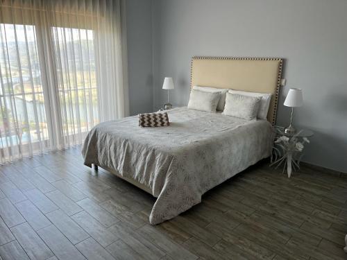 ein Schlafzimmer mit einem großen Bett und einem großen Fenster in der Unterkunft Quinta Pecêga - AL in Peso da Régua