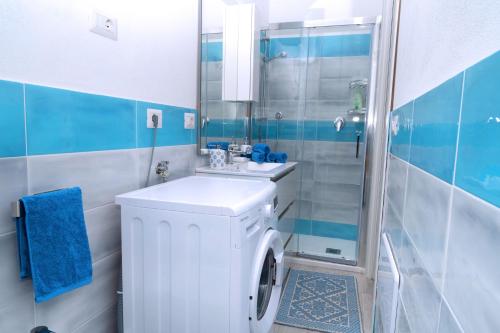 y baño con lavadora y ducha. en Dòmo#15 - Villino con piscina, 8 min dal mare, en Viddalba