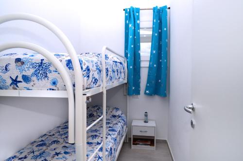 1 dormitorio con 2 literas en azul y blanco en Dòmo#15 - Villino con piscina, 8 min dal mare, en Viddalba