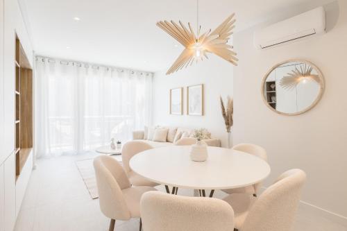 uma sala de jantar branca com uma mesa e cadeiras brancas em SANTA MONICA Parking gratuit em Annecy