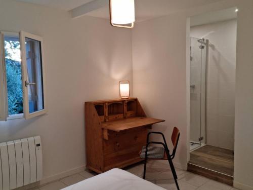 - une chambre avec un bureau, une chaise et une douche dans l'établissement Gîtes de l'Estagnol, à Villeneuve-lès-Maguelone