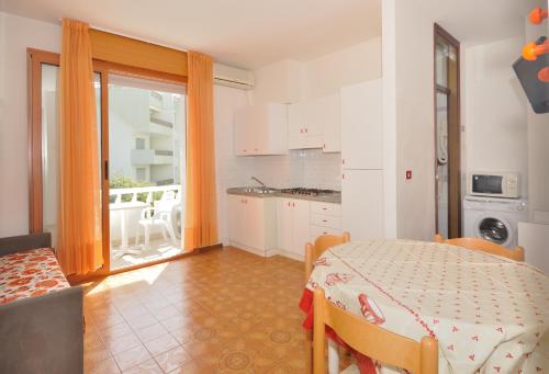 eine Küche mit einem Tisch und ein Esszimmer mit Aussicht in der Unterkunft Residence Ranieri in Bibione