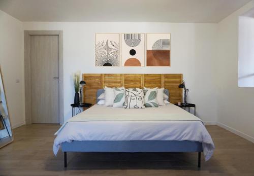 Club Tropicana Boutique Apartments في سان فيليس سيرسيو: غرفة نوم بسرير كبير مع اللوح الخشبي