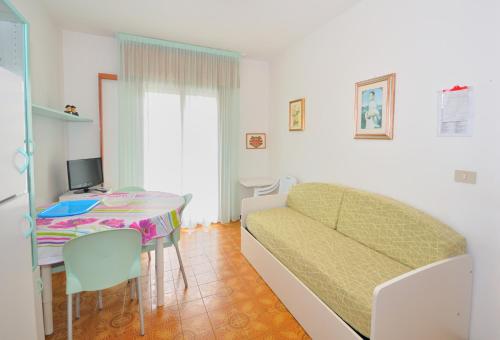 ein Wohnzimmer mit einem Sofa und einem Tisch in der Unterkunft Residence Ranieri in Bibione