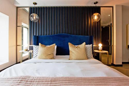 a bedroom with a large bed with a blue headboard at 37GS Residences in London
