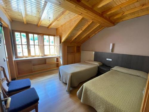 um quarto de hotel com duas camas e uma janela em PENSION CASA MIÑO em Pola de Somiedo
