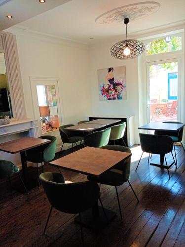 un restaurant avec des tables et des chaises dans une salle dans l'établissement Hôtel de France, à Pléneuf-Val-André