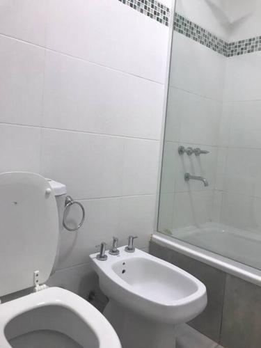 een witte badkamer met een toilet en een wastafel bij Departamento Beltrán in Godoy Cruz