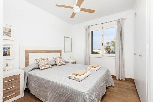 Un dormitorio blanco con una cama y una ventana. en Casa Tanalina, en Arenal d'en Castell