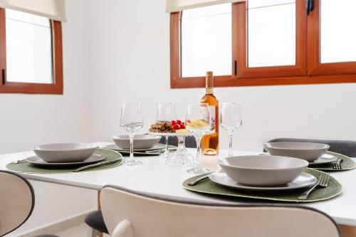 a dining room table with plates and wine glasses at Orkos Naxian Wave 3 in Mikri Vigla