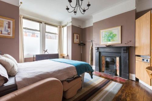 a bedroom with a bed and a fireplace at Modern Private Studio Room in London