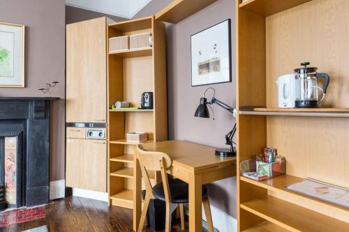 cocina pequeña con mesa de madera y fogones en Modern Private Studio Room en Londres