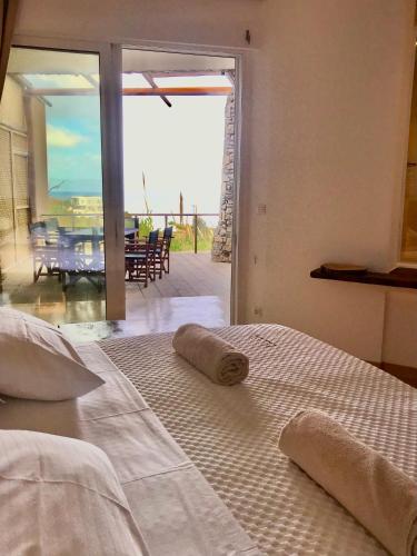 a bedroom with two beds and a view of a patio at KLIDON Dreamy Living Suites in Mikonos