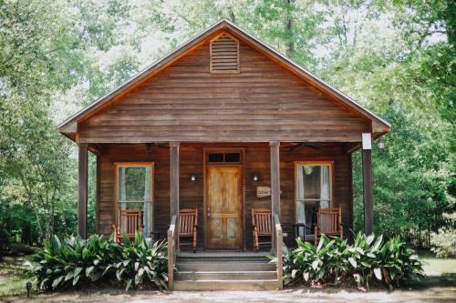 a wooden cabin with chairs and a door at The Myrtles in Saint Francisville