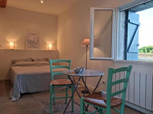 - une chambre avec un lit, une table et deux chaises dans l'établissement Gîtes de l'Estagnol, à Villeneuve-lès-Maguelone