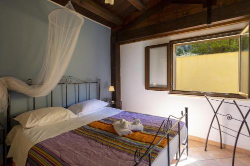 Schlafzimmer mit einem Bett und einem Fenster in der Unterkunft Il Carrubo in Marsala