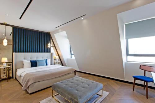 a bedroom with a king sized bed and a blue stool at 37GS Residences in London