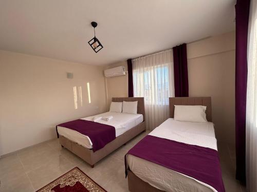 a bedroom with two beds and a window at The Titanic House Hotel in Pamukkale