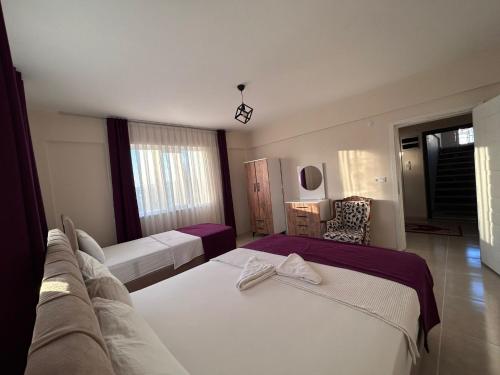 a hotel room with two beds and a chair at The Titanic House Hotel in Pamukkale