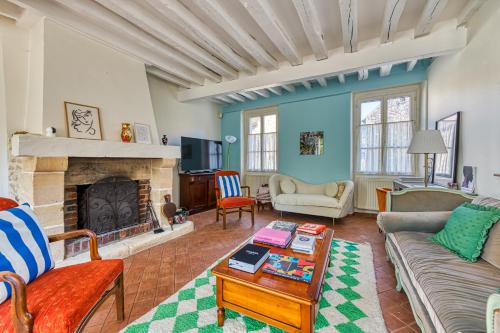 un salon avec un canapé et une cheminée dans l'établissement Maison Prado - avec piscine privée et grand jardin, à Magny-en-Vexin