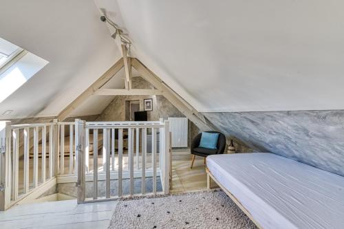 a attic room with a bed and a chair at Maison Prado - avec piscine privée et grand jardin in Magny-en-Vexin