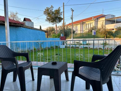 three chairs and a table on a balcony with a view at The Titanic House Hotel in Pamukkale