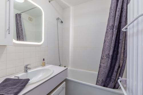La salle de bains est pourvue d'un lavabo et d'un miroir. dans l'établissement Duplex Croisette - Duplex à Bernières-sur-Mer, à Bernières-sur-Mer