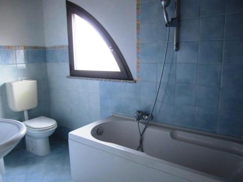 baño con bañera, aseo y ventana en Almare 38, en Grado