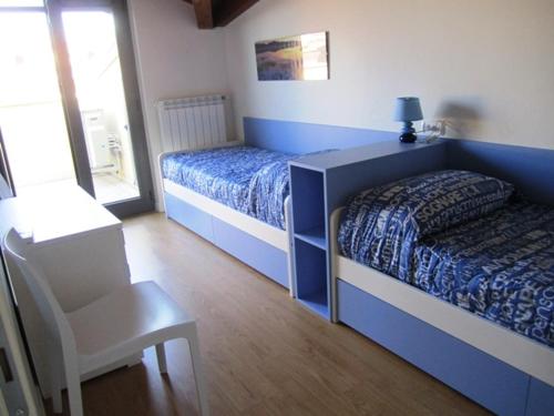 1 dormitorio azul con 1 cama y 1 silla en Almare 38, en Grado