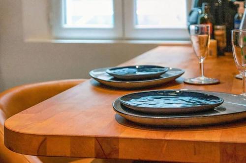 uma mesa de madeira com dois pratos e copos em Chez Cam - Paris Rooftop em Paris