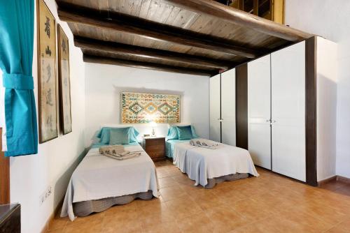 2 łóżka w pokoju z białymi ścianami w obiekcie Casa Bril w mieście São Bartolomeu de Messines