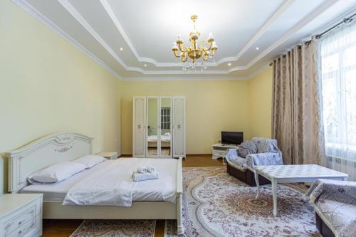 1 dormitorio con cama, sofá y lámpara de araña en Apartament Nazarbaeva 119, en Almaty