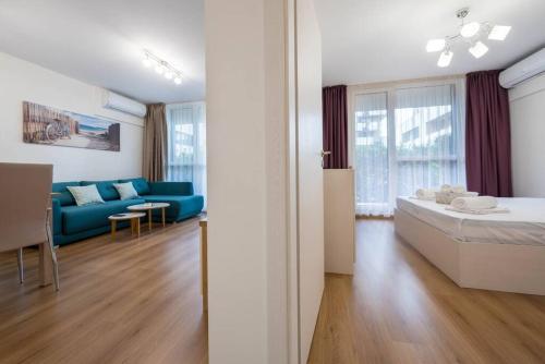 Habitación con cama y sofá azul. en Labyrinth Apartment - free parking space included, en Varna