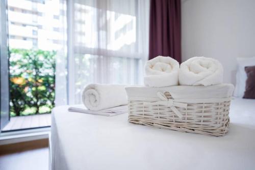 a basket of towels on a table with a window at Labyrinth Apartment - free parking space included in Varna City