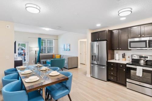 a kitchen and dining room with a table and blue chairs at 4013 Breakview Drive 108 in Orlando
