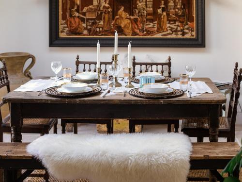 a wooden table with plates and candles on it at Little Oakley Cottage in Sandford Saint Martin