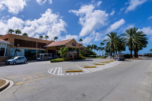 an empty street with a building and palm trees at Divi Village Condo 9 in Palm-Eagle Beach