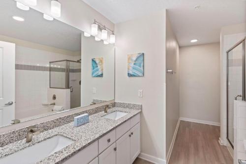 uma casa de banho com 2 lavatórios e um espelho grande em 4012 Breakview Drive 110 em Orlando