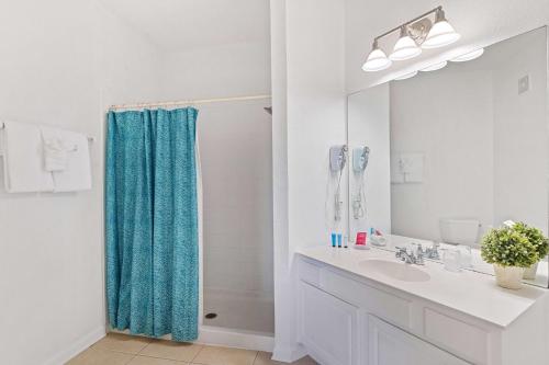 een badkamer met een blauw douchegordijn en een wastafel bij 4814 Cayview Avenue 406 in Orlando