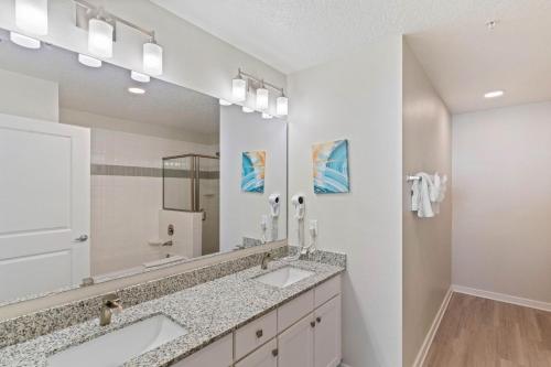 baño con 2 lavabos y espejo grande en 4012 Breakview Drive 410 en Orlando
