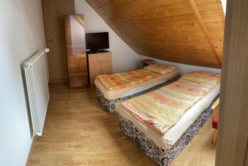 2 Betten in einem kleinen Zimmer mit einer Treppe in der Unterkunft Privatsalatin 