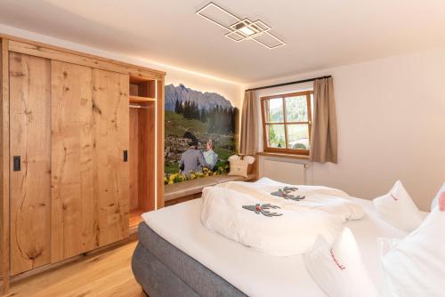 Schlafzimmer mit einem Bett mit weißer Bettwäsche und einem Fenster in der Unterkunft Ferienwohnungen Fam Michael Neumaier in Reit im Winkl