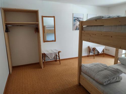 a bedroom with two bunk beds and a mirror at Zum Hüttenklaus - 12 Personen Gruppenunterkunft in den Bergen mit eigenem Badezuber in Bad Hindelang