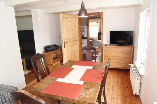 uma sala de jantar com uma mesa e cadeiras e uma televisão em Sandkasten em Upleward